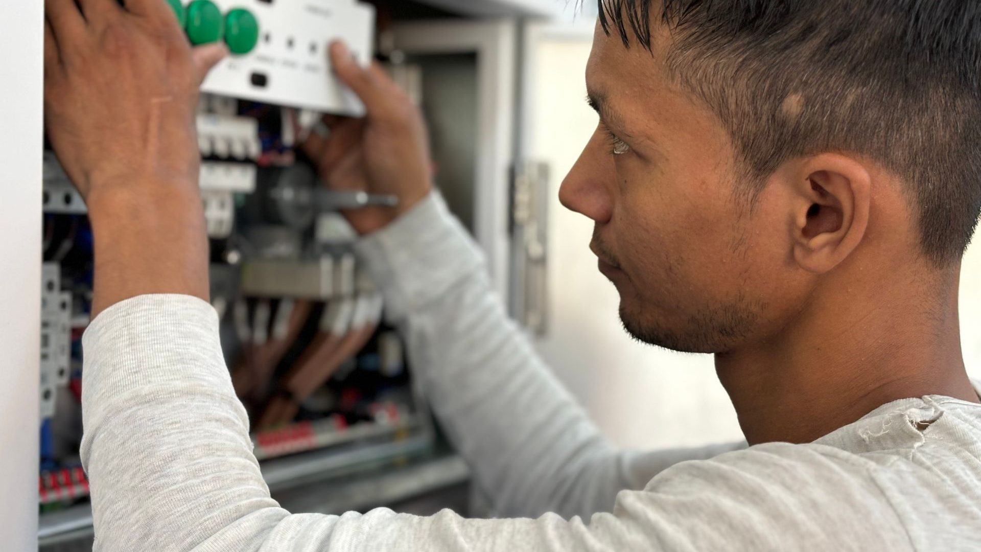 Elektriker arbeitet an einem offenen Schaltschrank