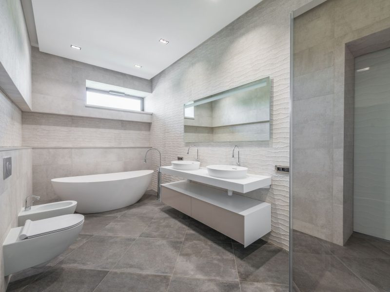 Modernes helles Badezimmer mit freistehender Badewanne und Doppelwaschtisch