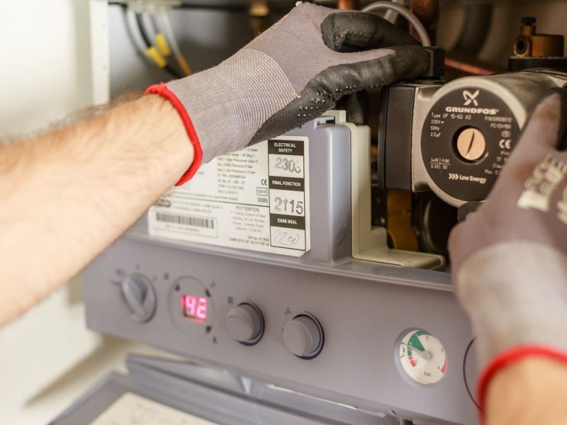Handwerker verschweißt Rohrleitung in einem Erdgraben